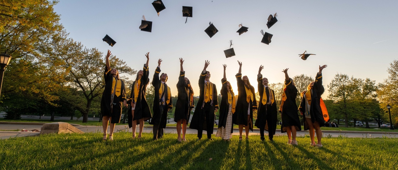 Graduates throwing their caps in air in the distance