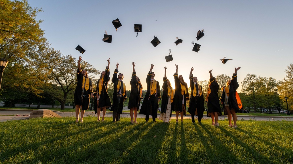 Graduates throwing their caps in air in the distance